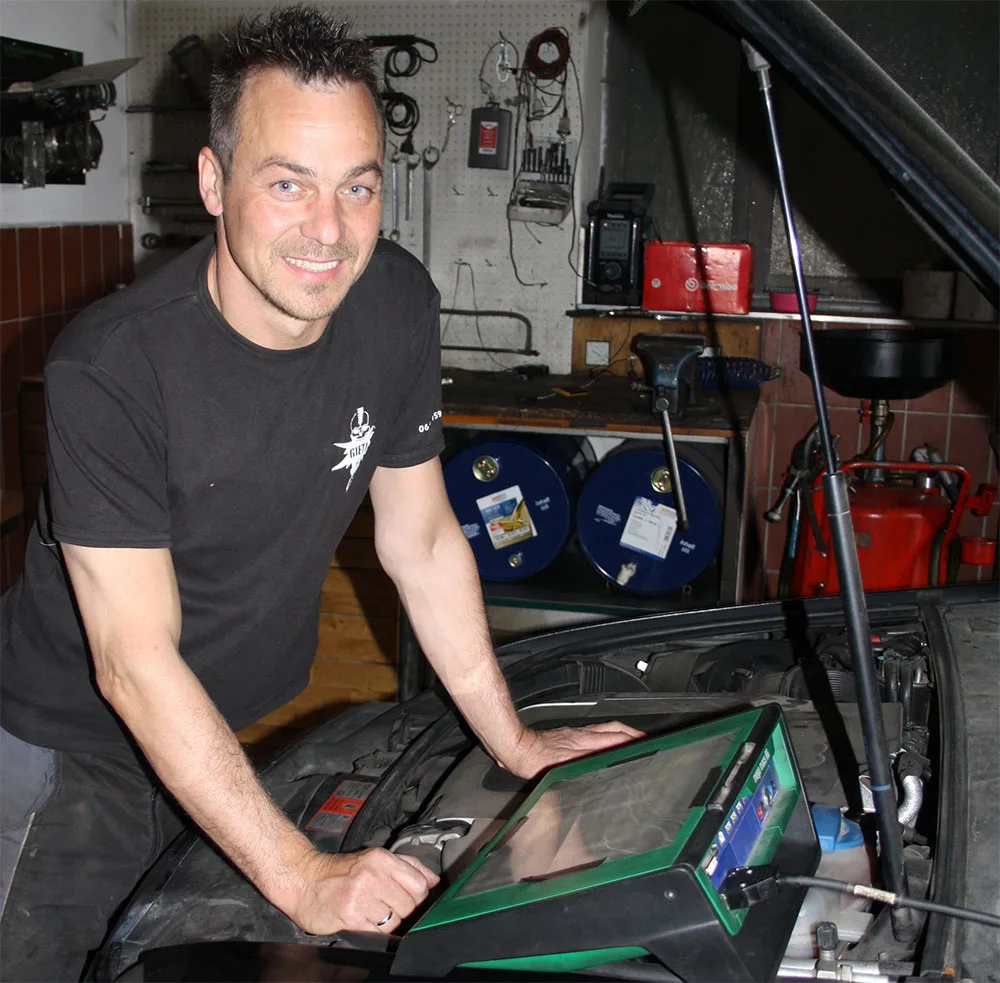 Wolfgang Gietl mit Diagnosegerät am Motorraum
